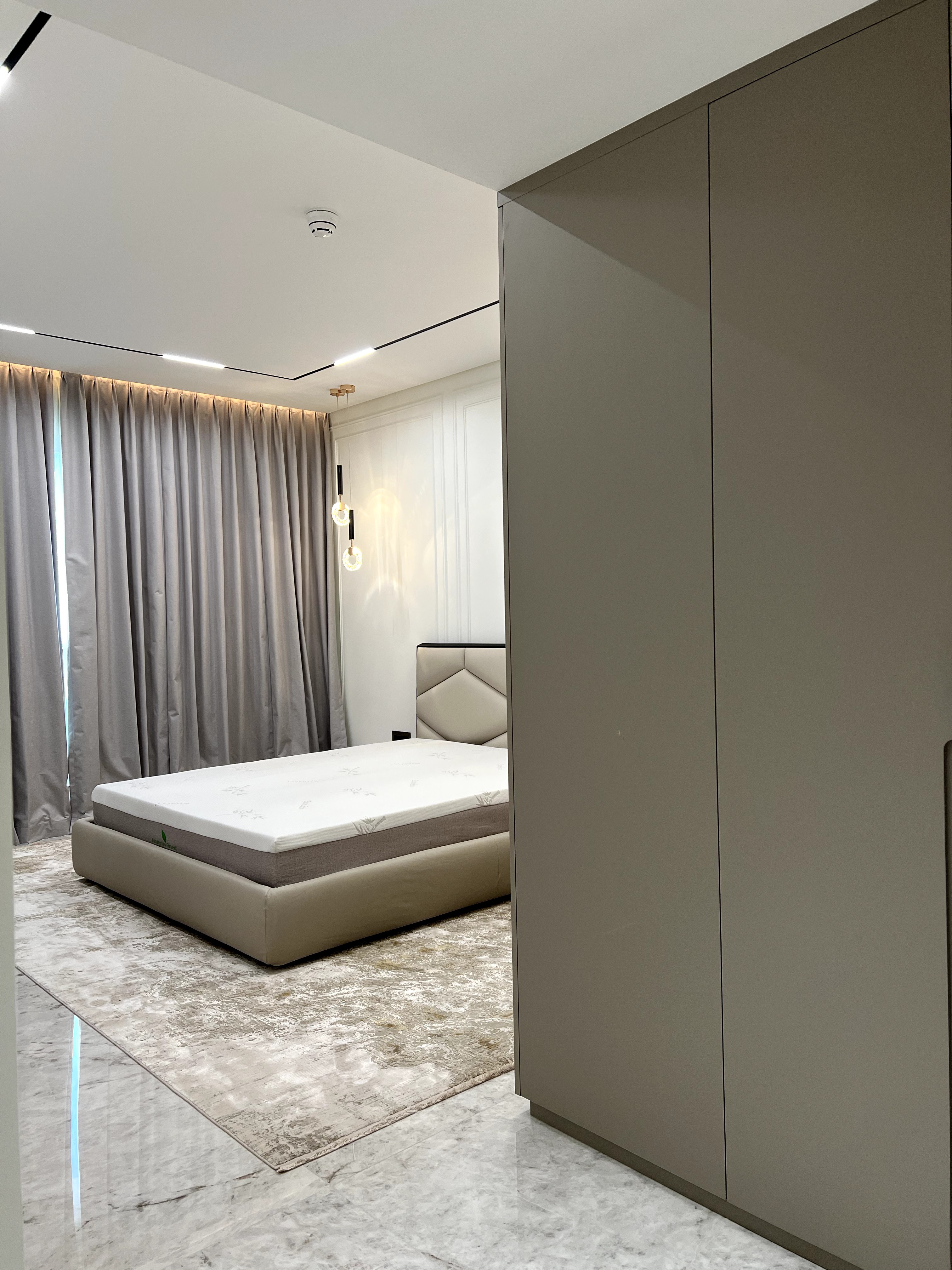 Modern serene bedroom with upholstered bed and pendant lights