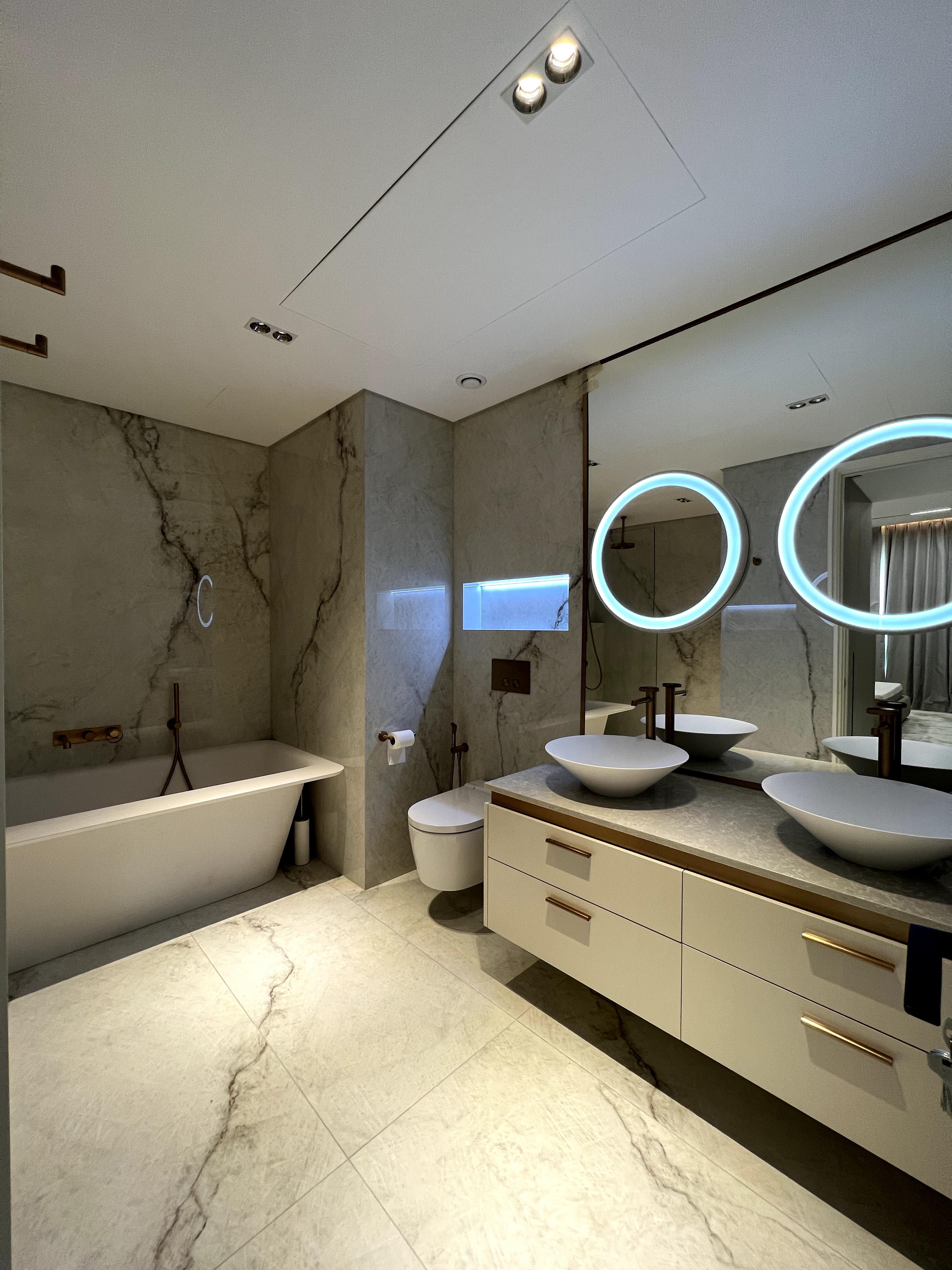 Luxurious modern bathroom with marble-look tiles and dual floating vanity