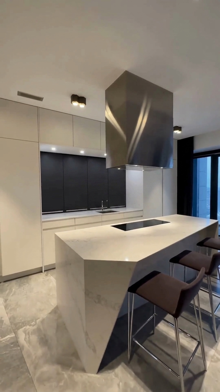 Contemporary kitchen with large marble island and integrated induction hob