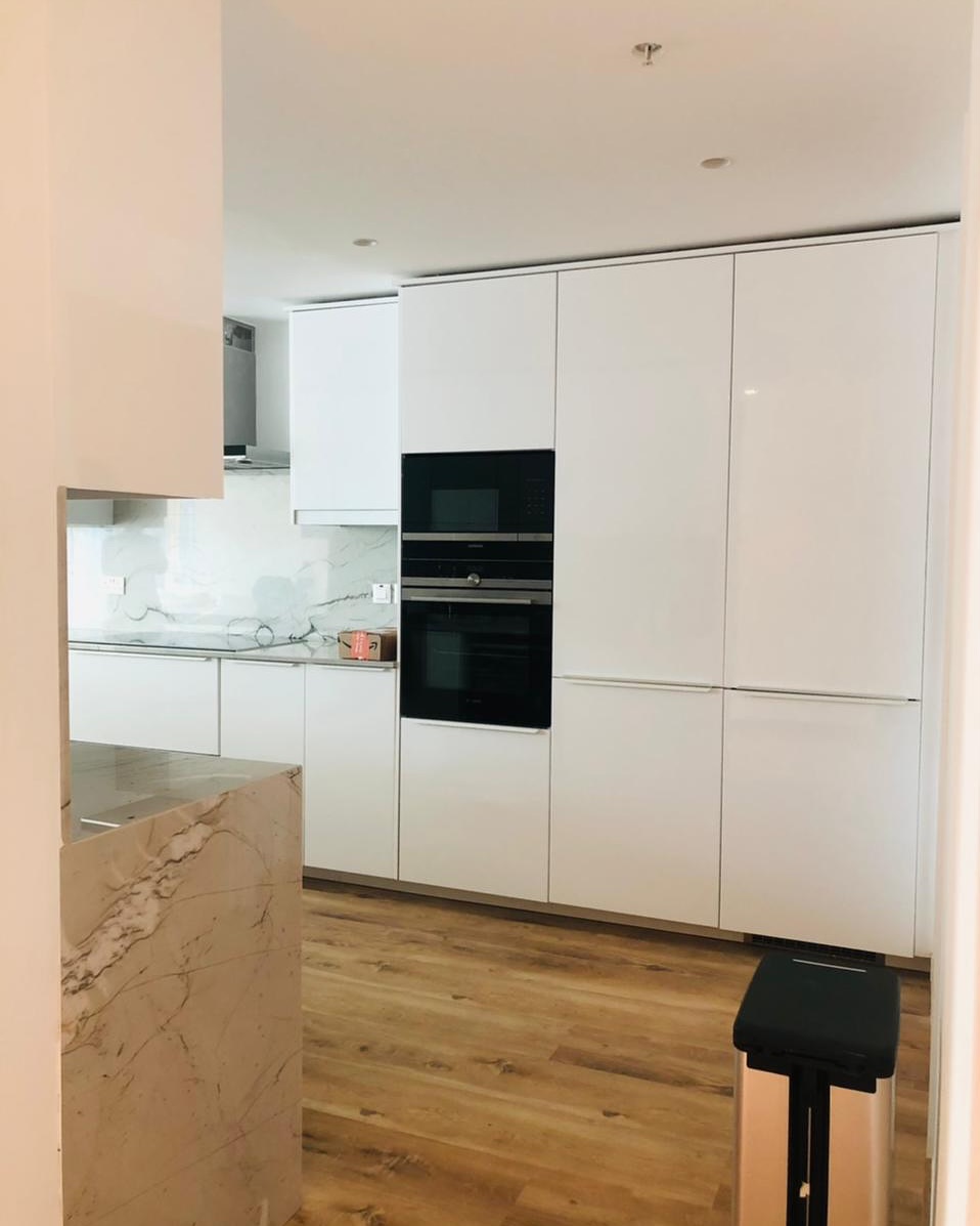 Modern kitchen with white glossy cabinets and marble-clad island