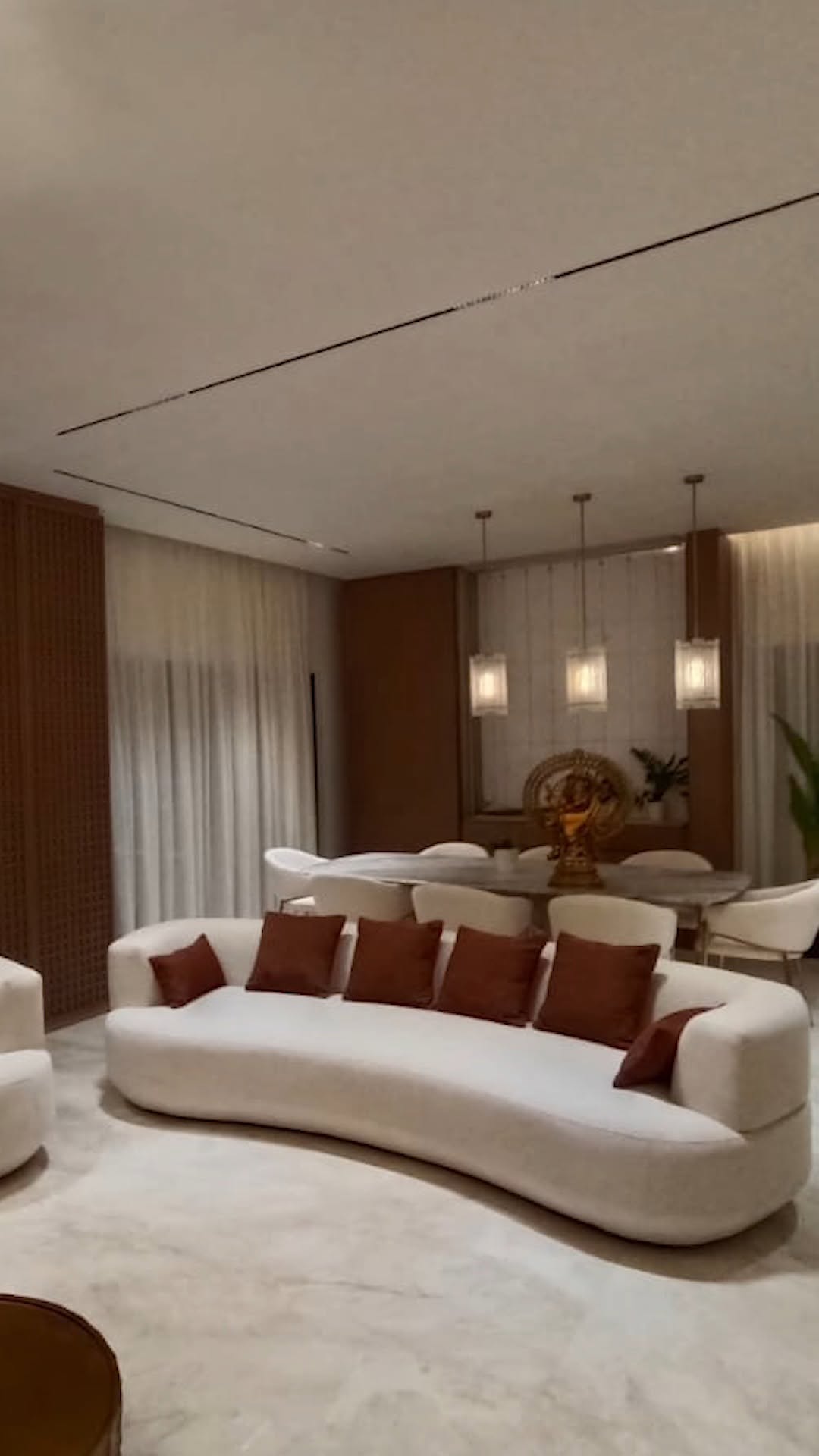 Luxurious open-plan living and dining room with curved sofa and modern interior design