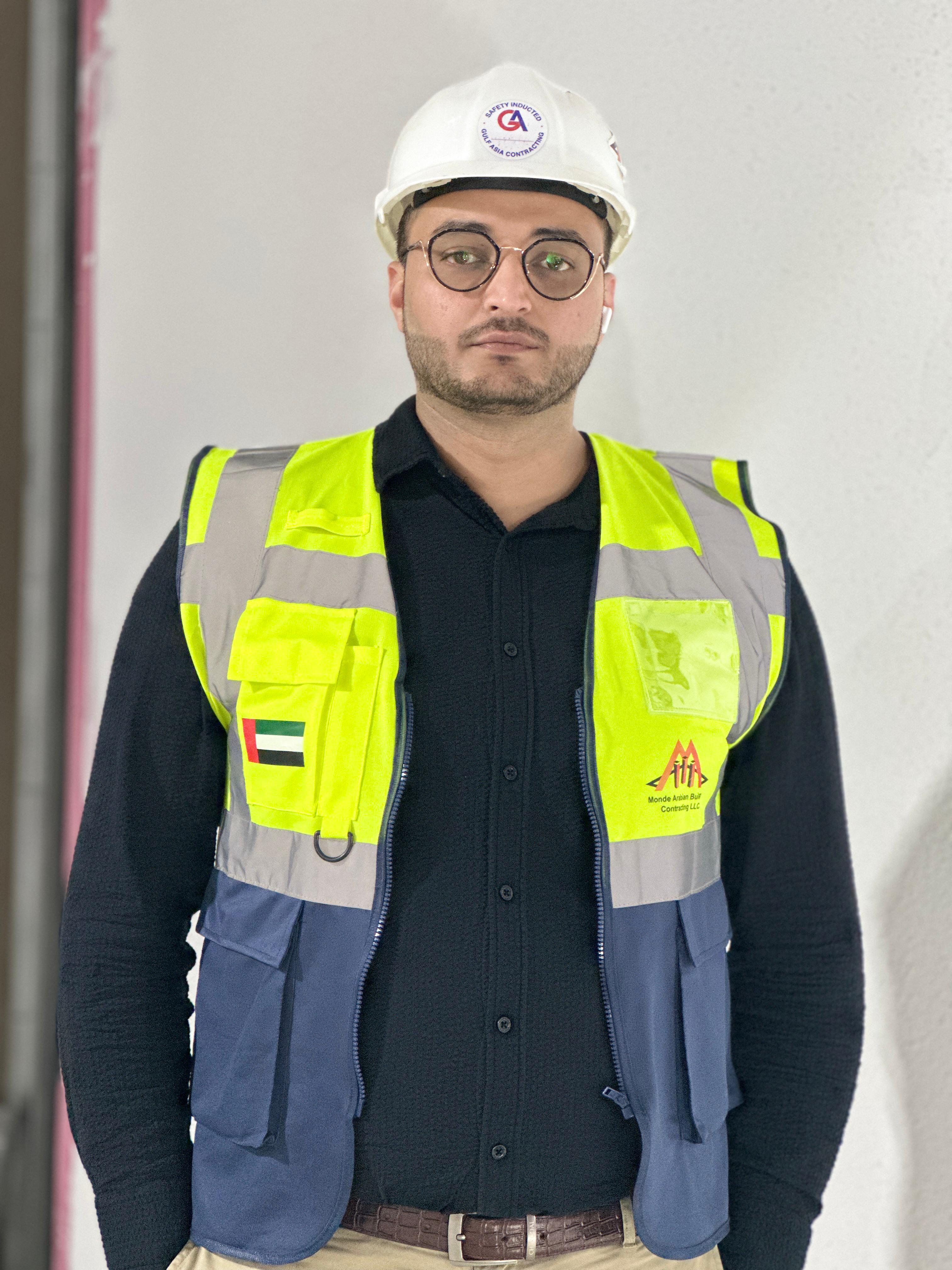 A construction professional wearing a hard hat and high-visibility vest, representing a contracting company