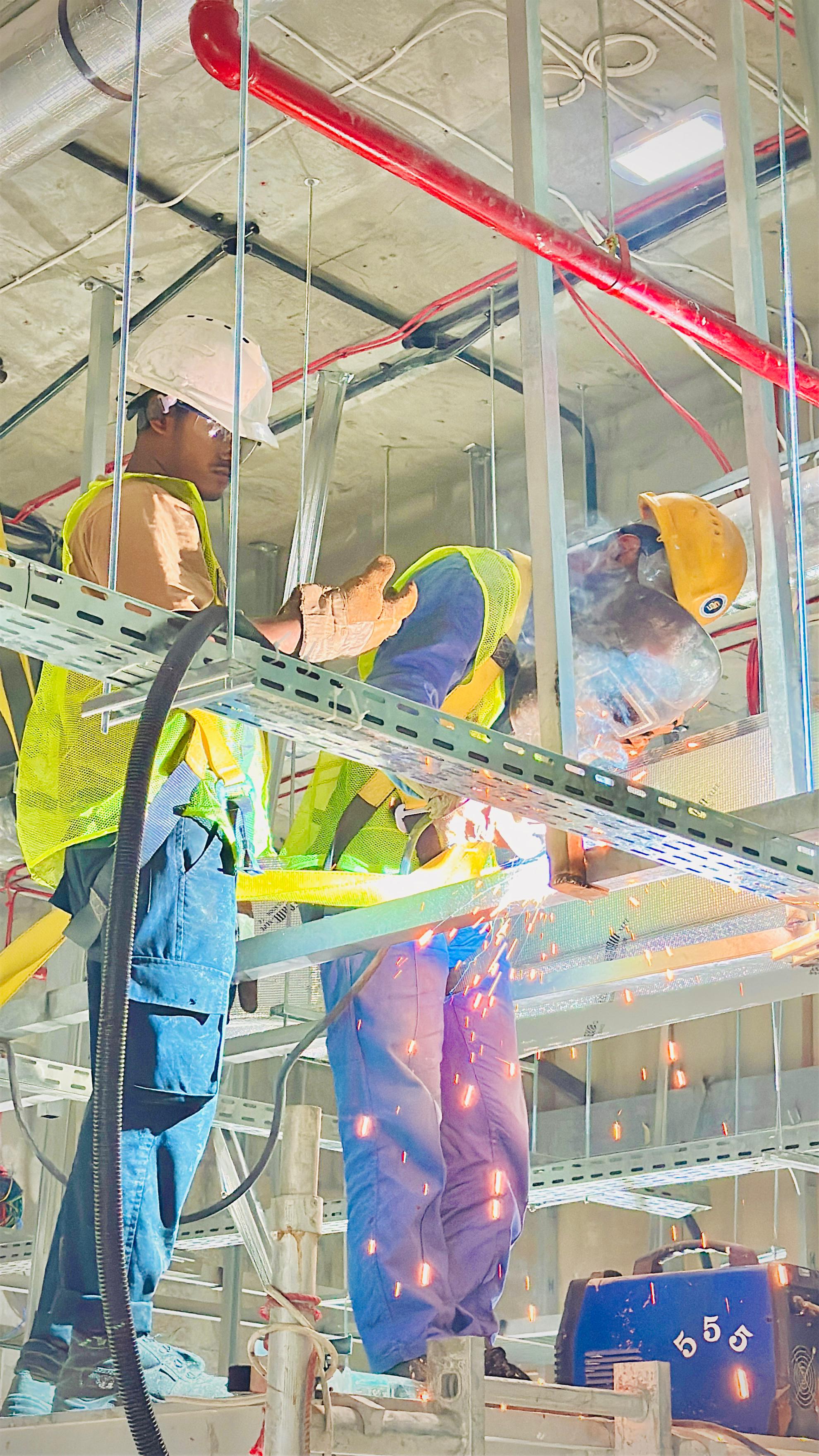 Monde workers welding on site — in-house tradesmen, not subcontractors