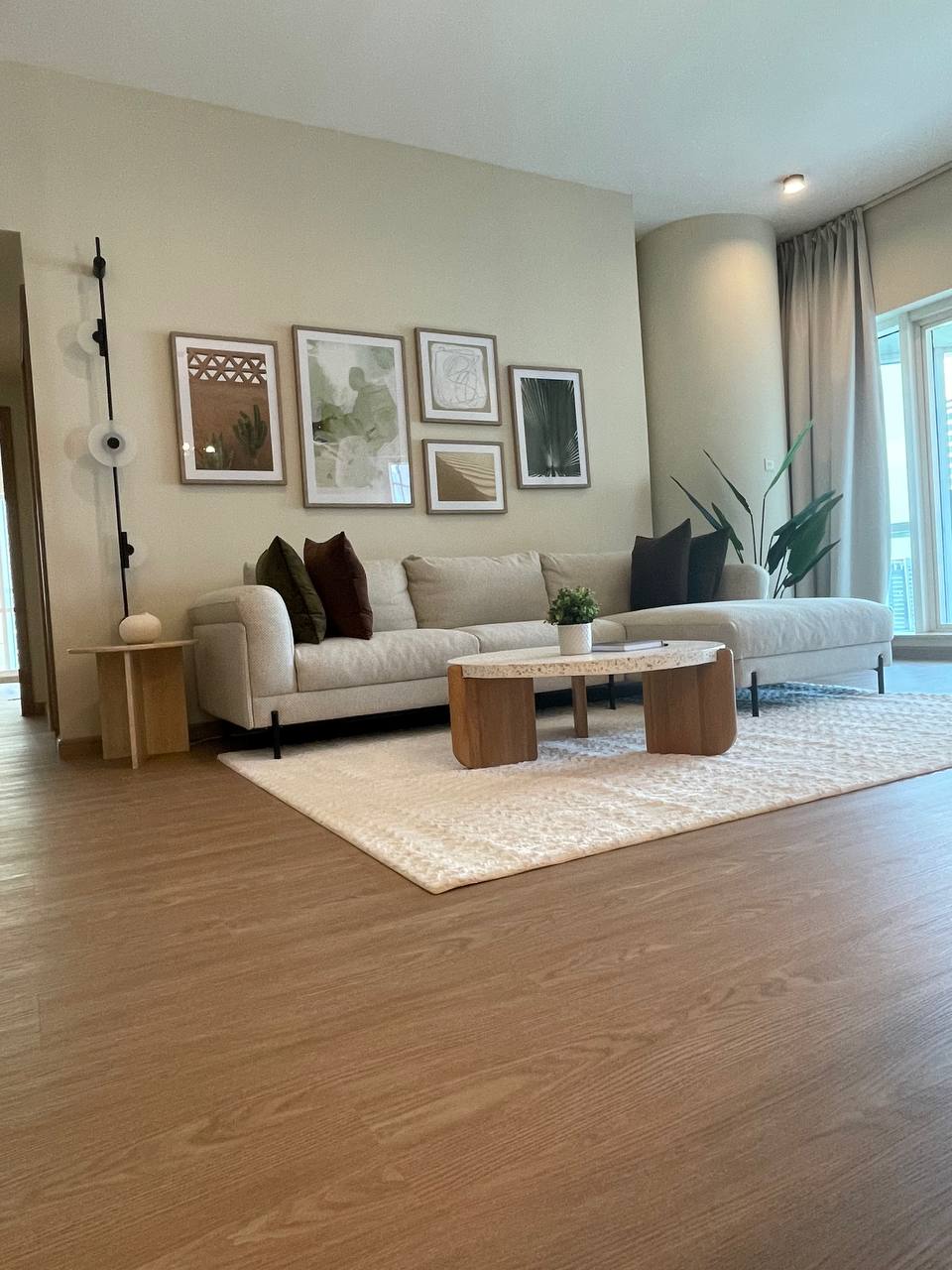 A modern and spacious living room featuring a neutral color palette and large beige sectional sofa