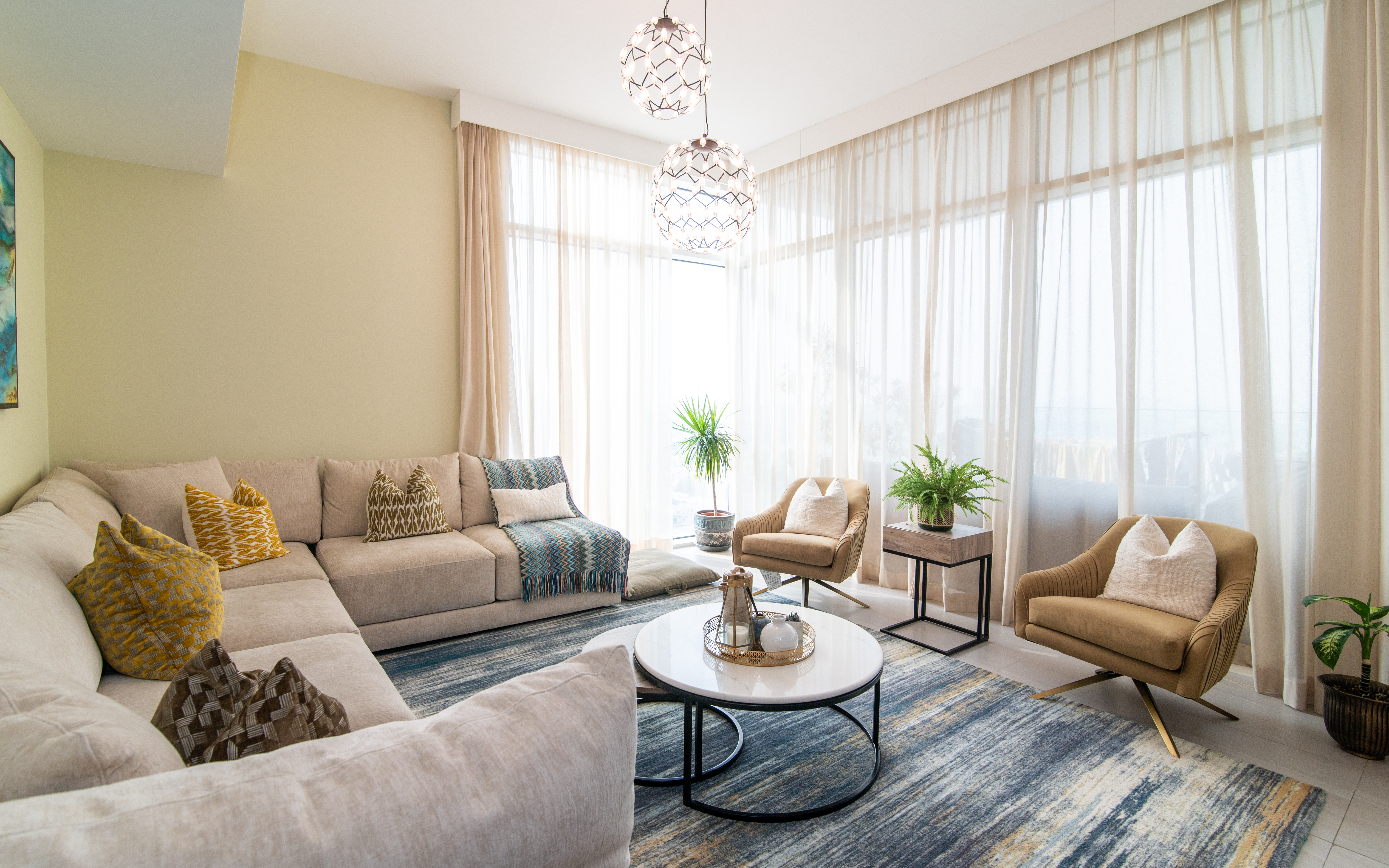 Luxury Marina apartment living room with cream sectional and floor-to-ceiling sheers
