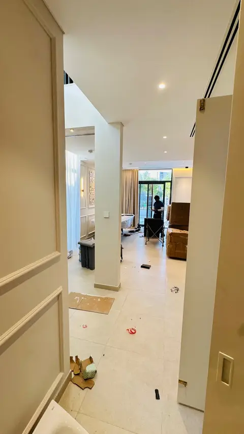 Fit-out progress shot of an open-plan residential interior with worker on site
