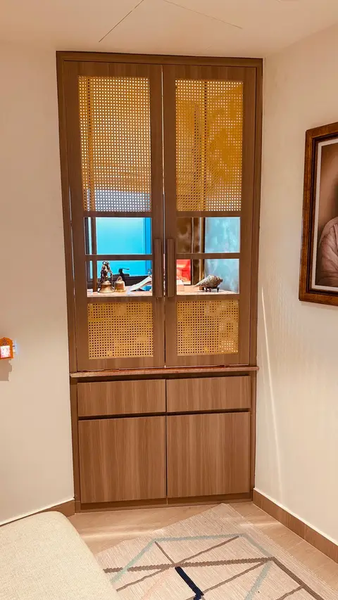 Custom wooden cabinet with cane webbing doors and brass decor, built in CLARE workshop