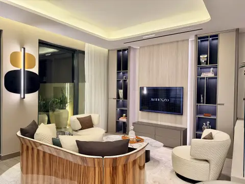 A curved cream leather sofa with a wood veneer base, custom shelving with an integrated TV, and — MODENZO INTERIORS L.L.C