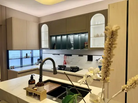 A modern kitchen renovation featuring a white marble island, light wood and dark olive green — MODENZO INTERIORS L.L.C