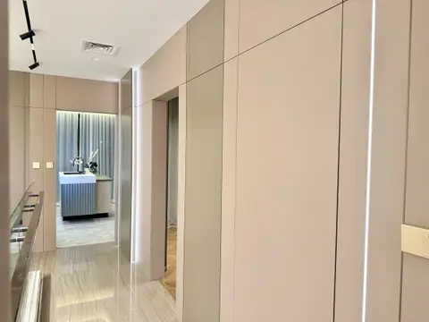 Integrated LED strip lighting and neutral wall paneling define this modern hallway, leading to a — MODENZO INTERIORS L.L.C