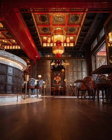 A luxurious and ornately designed bar and dining area, featuring a grand red and gold ceiling with — APEX STEEL WORKS L.L.C