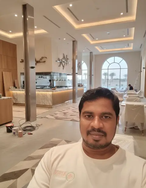 A man takes a selfie in a spacious, modern luxury restaurant interior, featuring a large white — APEX STEEL WORKS L.L.C