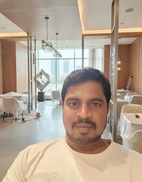 A candid selfie captures a man in a modern commercial interior space, likely a restaurant or — APEX STEEL WORKS L.L.C