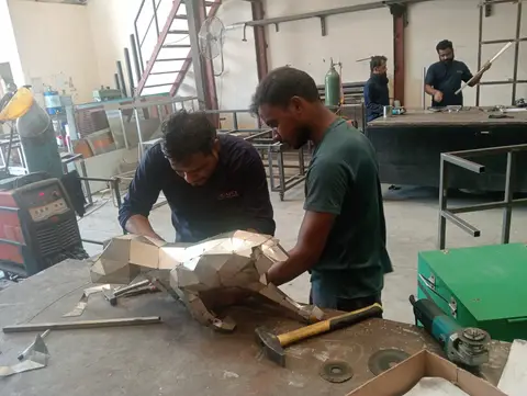 Skilled artisans in a bustling Dubai workshop meticulously assemble a striking geometric metal — APEX STEEL WORKS L.L.C