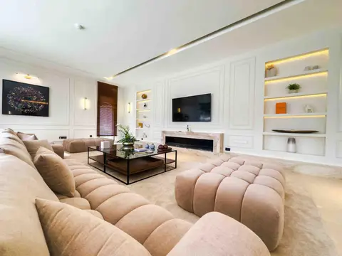 A beige sectional sofa, glass coffee table, and wall-mounted TV above a fireplace — Tasaddaq Mughal Technical Services