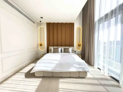 An upholstered bed frame with a fluted wood headboard, vertical pendant lights, and — Tasaddaq Mughal Technical Services