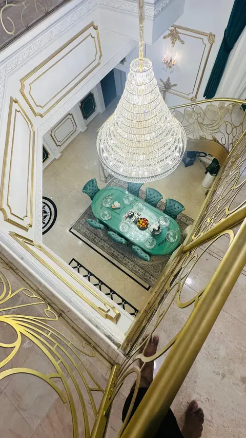 Opulent entrance hall with dining set and tiered crystal chandelier