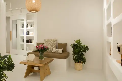 A beauty salon waiting area features a built-in bench, a natural wood coffee — CRAFTY CLARE DECORATION DESIGN L.L.C, Dubai
