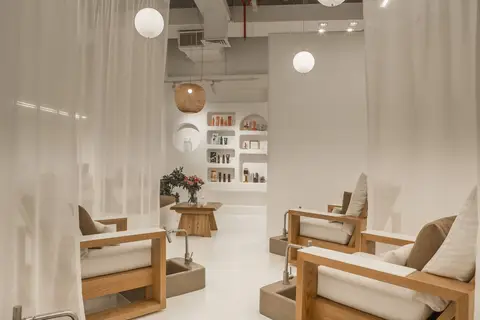 Light wood pedicure chairs with integrated concrete basins and arched display — CRAFTY CLARE DECORATION DESIGN L.L.C, Dubai