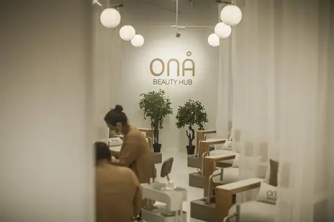 A serene beauty hub interior with a prominent brand logo, spherical pendant — CRAFTY CLARE DECORATION DESIGN L.L.C, Dubai
