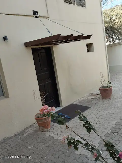 Modern residential entrance with canopy and potted plants