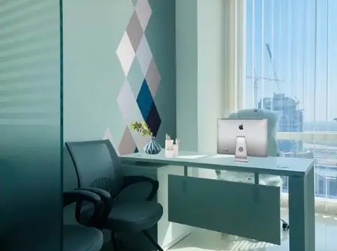 An office workstation with a teal feature wall and a window view, part of a — NOOR AL SUNDUS CONTRACTING L.L.C, Dubai