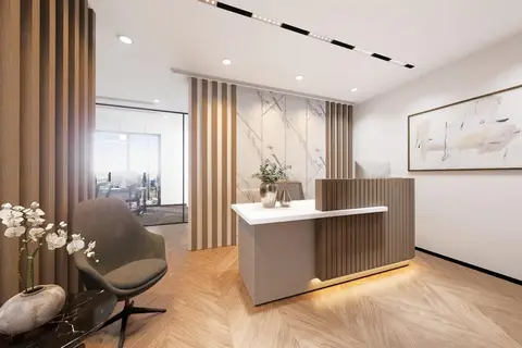 A modern and elegant office reception area features a custom wood-slatted desk with integrated under-lighting, set again