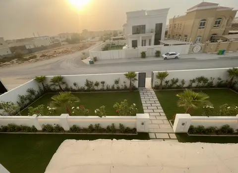 An elevated view captures a meticulously landscaped garden with a modern stone pathway and lush greenery, set — Monde