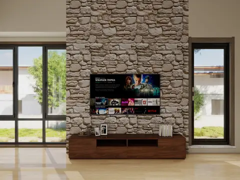 A well-lit modern living room features a prominent television mounted on a textured stone accent — Anel&CO, Business Bay