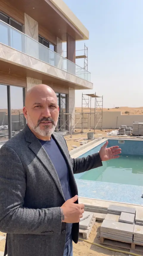 Exterior construction of a modern villa is underway, featuring a partially filled swimming pool — Chadi Baaklini, Dubai