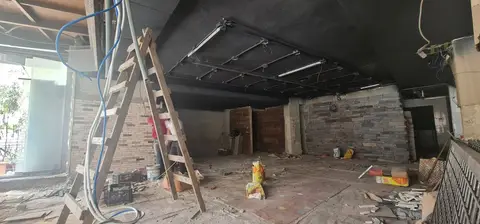 An interior commercial space is captured mid-renovation, showcasing exposed brick walls, a dark — Chadi Baaklini, Dubai