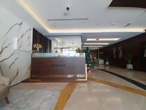 A dark wood reception desk, white marble wall with gold veining, and a — MINGASH ENGRAVING & ORNAMENTATION WORKS EST.