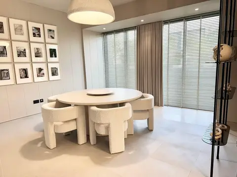 This serene modern dining room features a round light wood table — Lacasa Line Decoration Design And Fitout LLC, Dubai