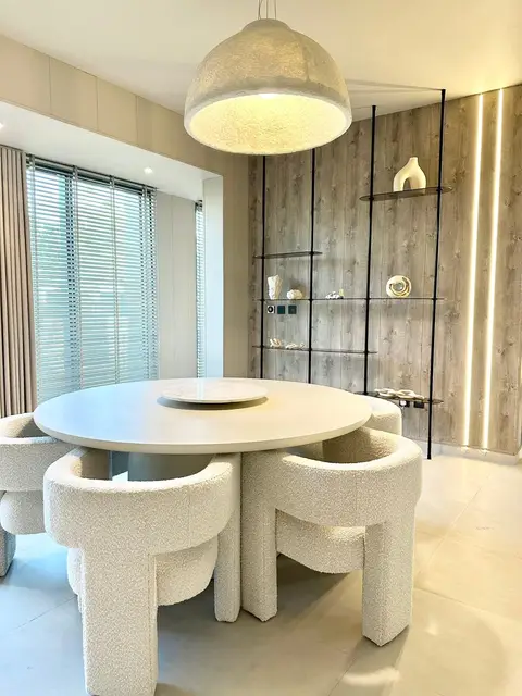 This contemporary dining room features a striking round table — Lacasa Line Decoration Design And Fitout LLC, Dubai
