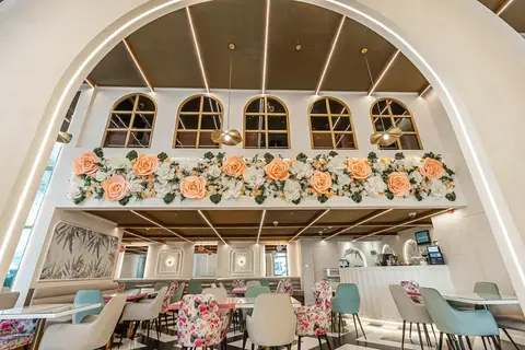 A modern cafe interior features a large-scale paper floral wall installation, arched windows, linear — Muhammed  Gani
