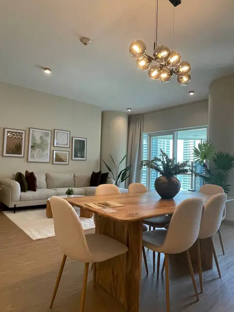 A beautifully furnished open-plan living and dining area features a modern organic — ROUND TRIANGLE DECORATION CO. L.L.C