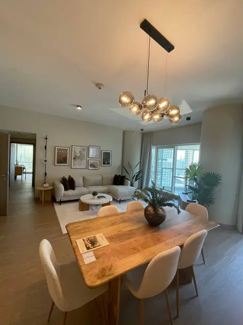 A warm and inviting open-plan living and dining area features a large wooden dining — ROUND TRIANGLE DECORATION CO. L.L.C