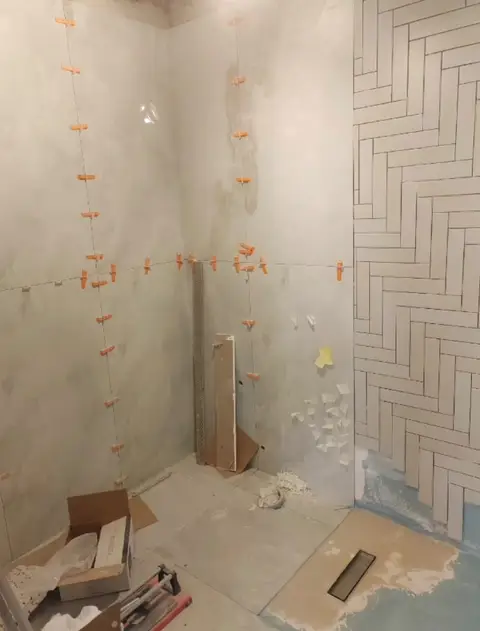 Modern bathroom renovation underway, featuring meticulous white subway tile installation in a — A&B Design & Build