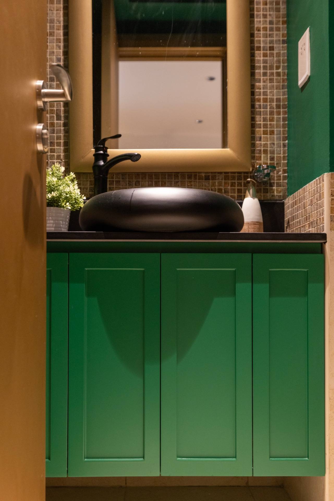 Emerald green double basin vanity unit Dubai with a black vessel sink, matte black faucet and gold framed mirror