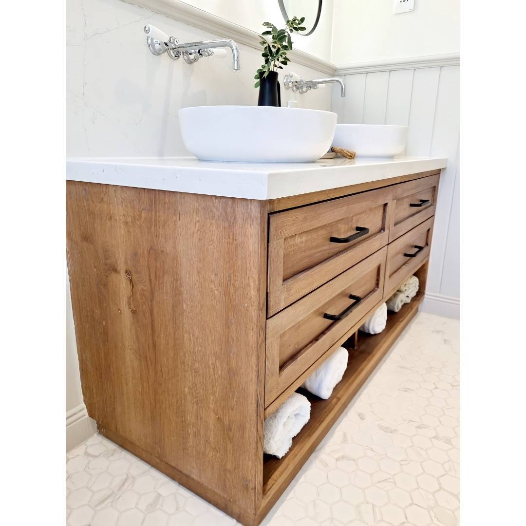 Double wood vanity with white marble countertop, white vessel sinks and black matte hardware in a modern rustic Dubai bathroom