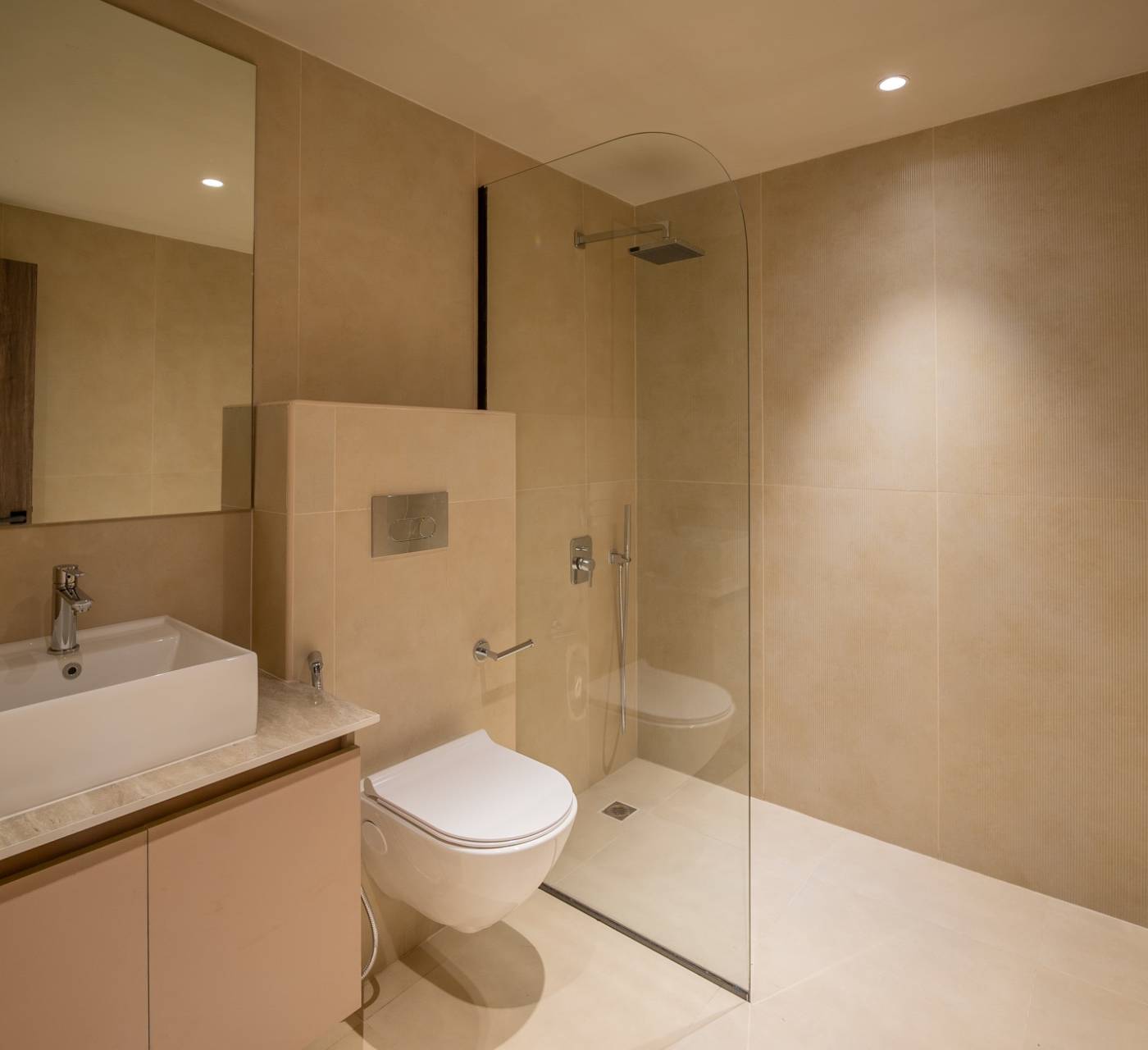 Modern minimalist bathroom with beige tiled walls, floating vanity and glass shower enclosure in a Dubai villa