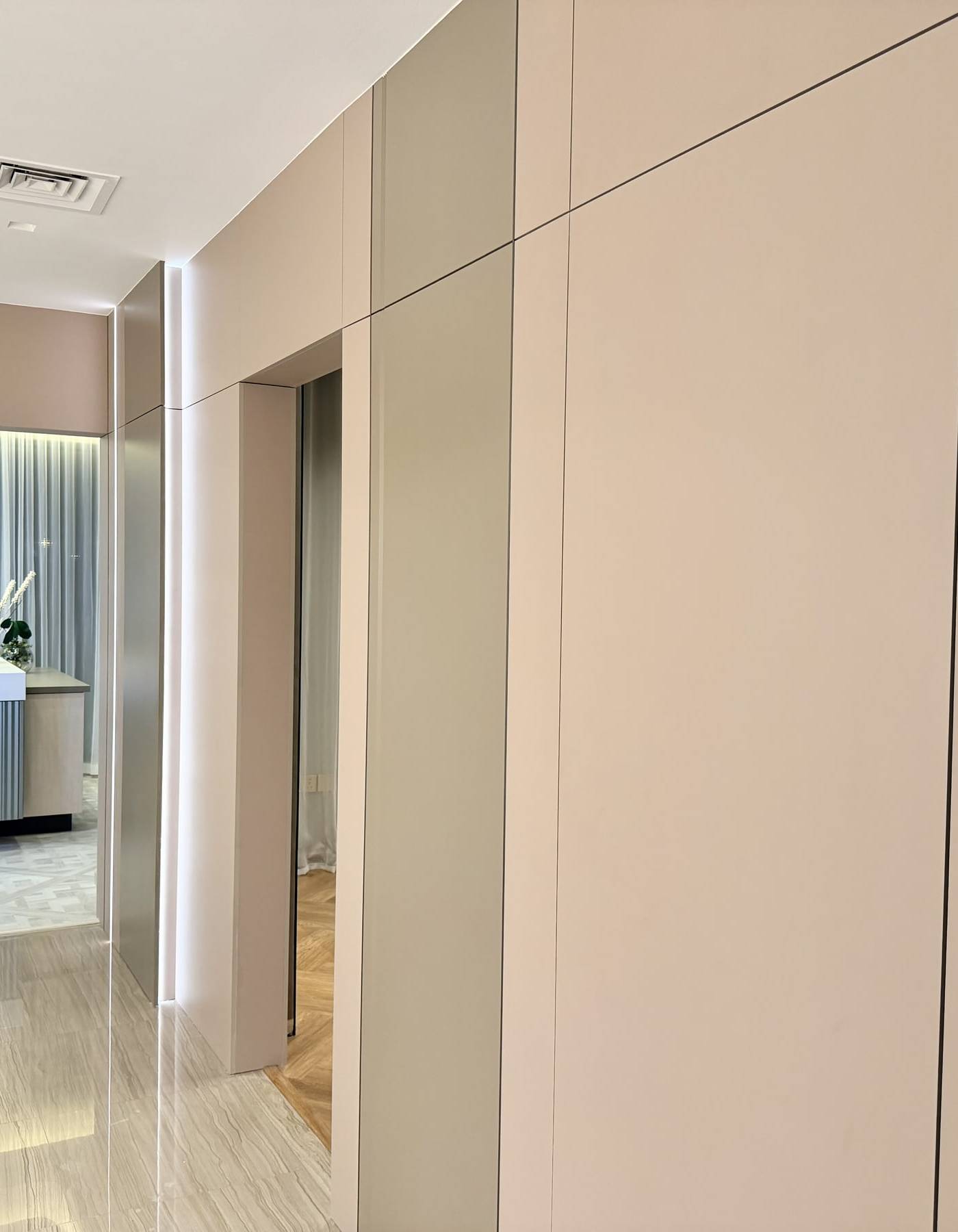 Walk in closet with a white marble topped island with a glass display, custom cabinetry and integrated lighting in a Dubai villa