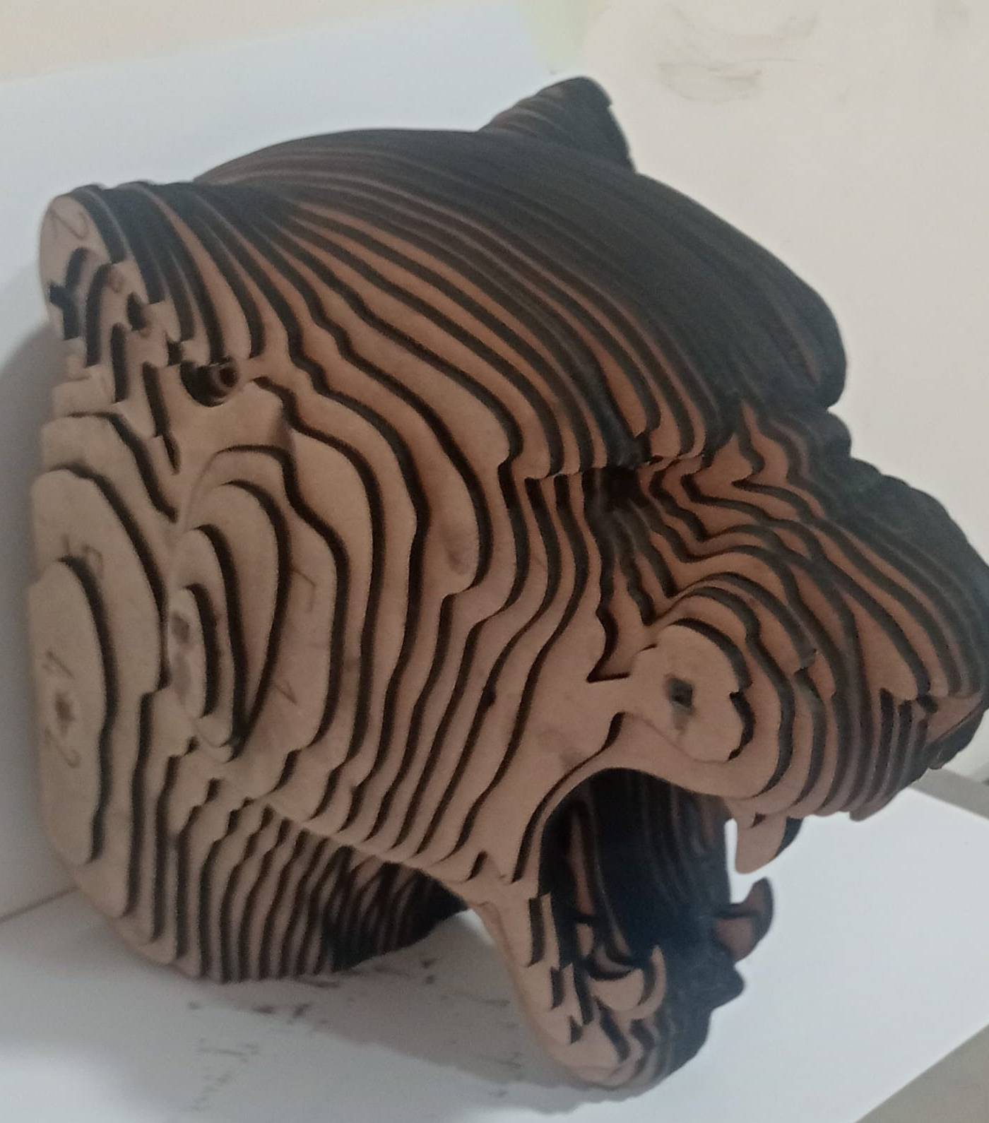 Stacked panel tiger head sculpture on a workshop surface showing the layered fabrication precision APEX applies to Abu Dhabi <a href=