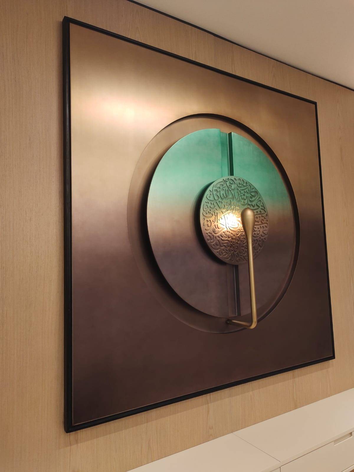 Multi-layered metallic wall art with Arabic calligraphy, showcasing <a href=