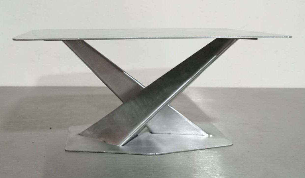 Minimalist steel table with brushed metal finish and X shaped base, a steel works Al Ain project