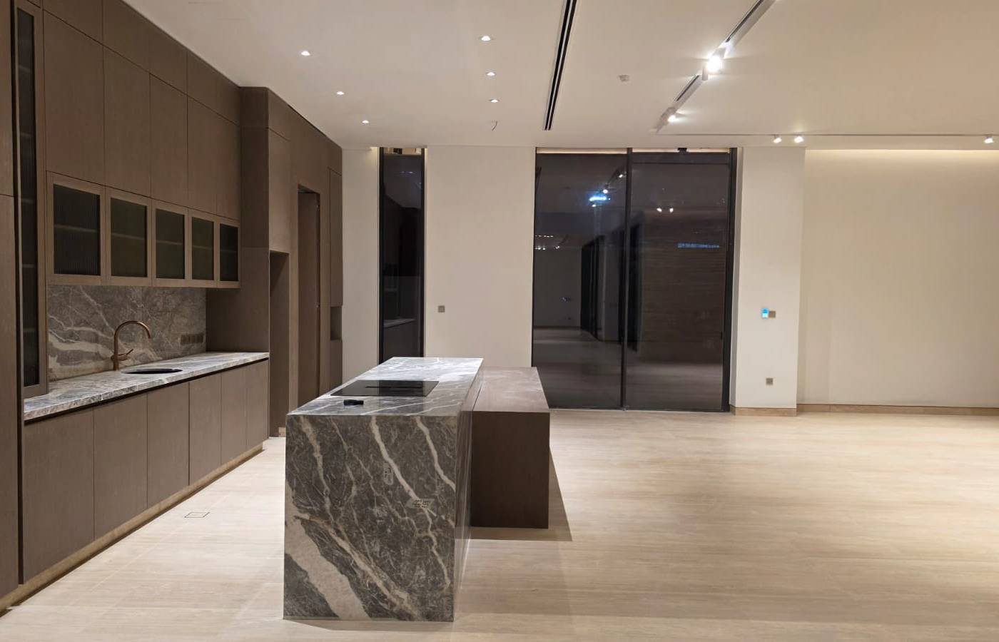 Dark wood cabinetry and marble island joinery in an open plan space