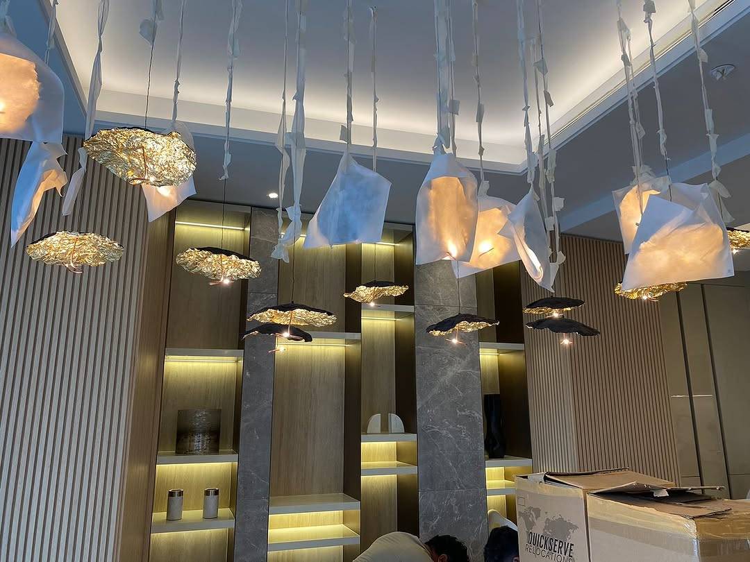Interior during fit out with organic pendant lights, warm wood panelling and marble accents