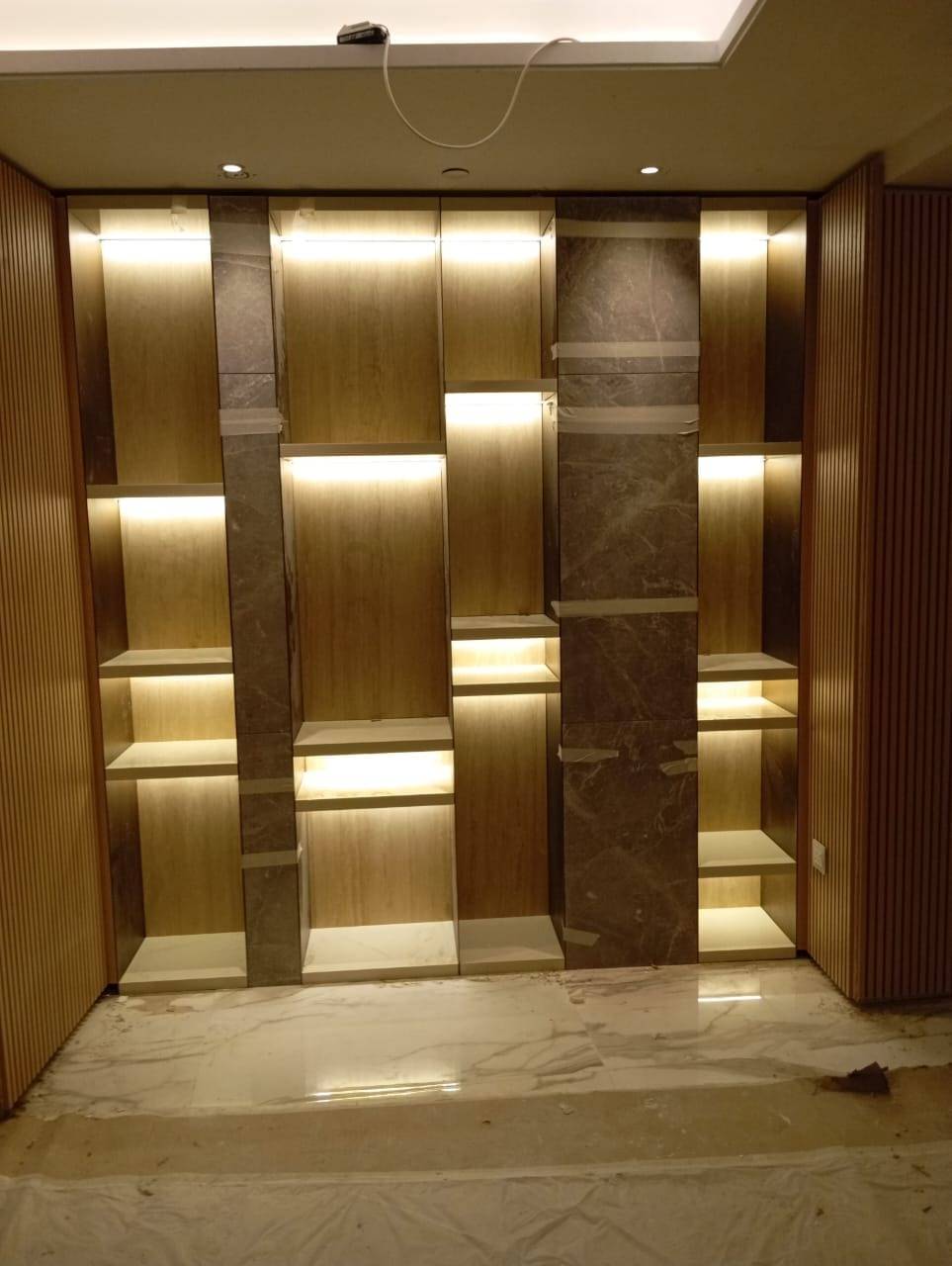 Lit timber and stone display unit — commercial fit-out by Noor Al Sundus Contracting, Dubai