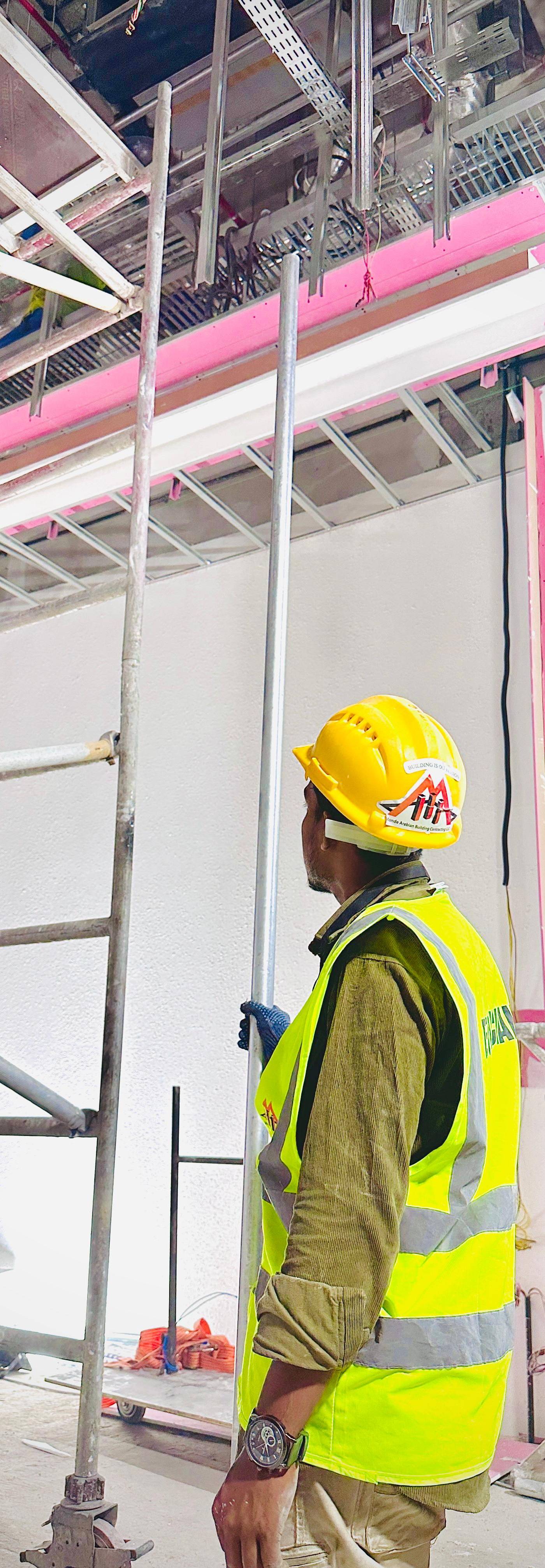 A Monde supervisor inspects exposed ceiling systems before final fitout — part of the meticulous office renovation process that controls costs in Dubai.