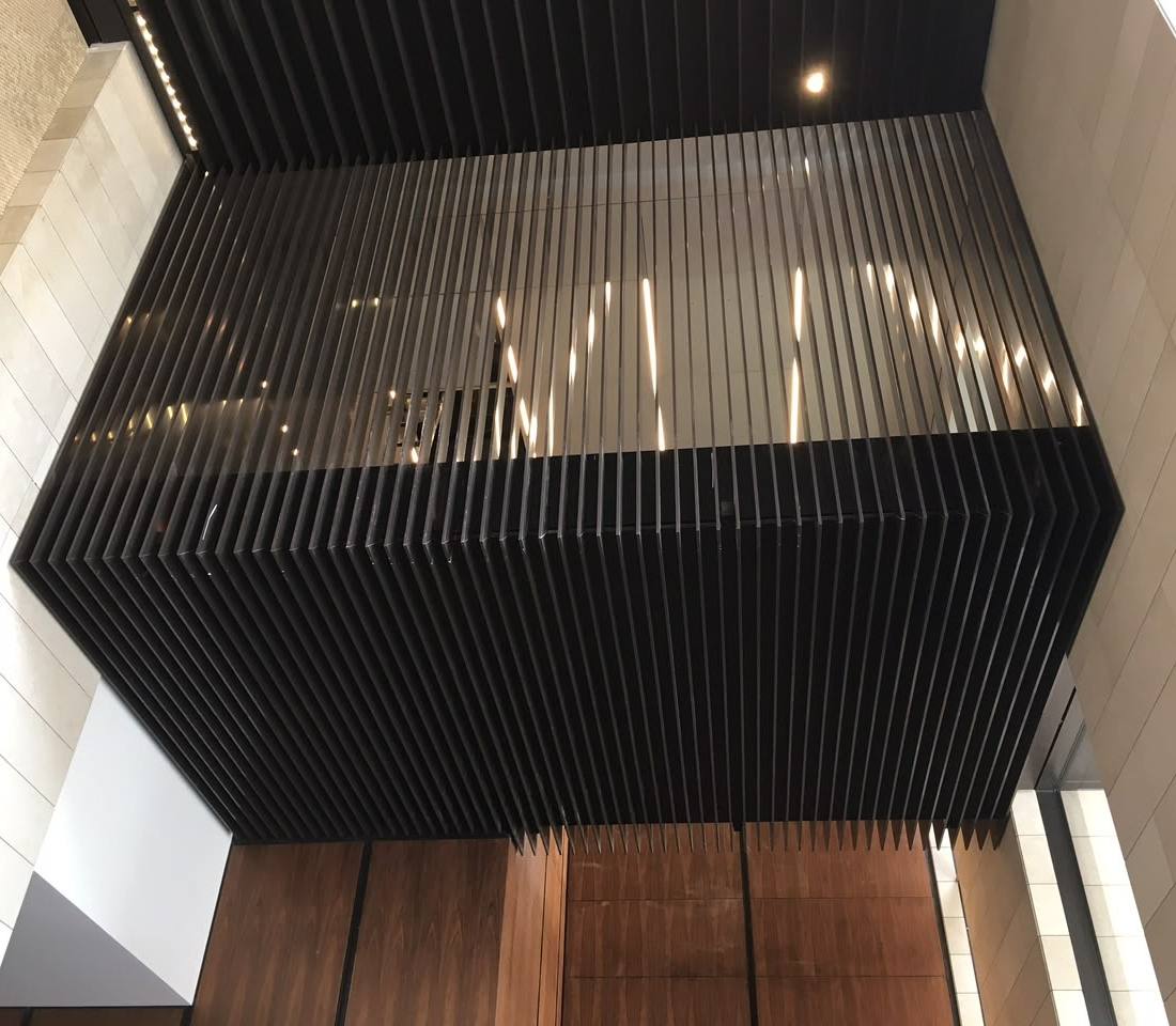 Slatted timber and black ceiling feature above a double-height void